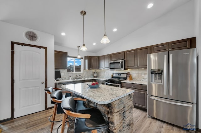 4400 Beringer Dr, Rapid City, SD 57703 - kitchen with a center island, lofted ceiling, light wood-style flooring, stainless steel appliances, and dark brown cabinets