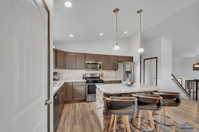4400 Beringer Dr, Rapid City, SD 57703 - kitchen with tasteful backsplash, lofted ceiling, a center island, light wood-style flooring, and appliances with stainless steel finishes