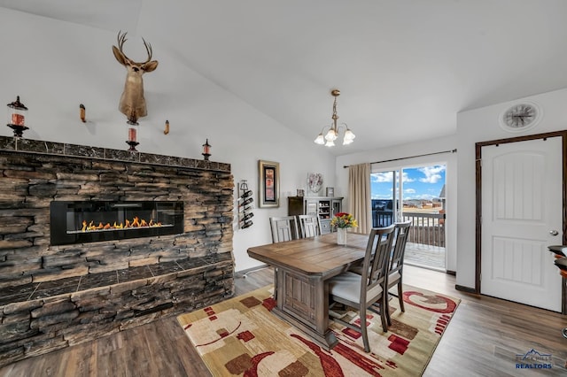 4400 Beringer Dr, Rapid City, SD 57703 - dining area featuring lofted ceiling, wood finished floors, an inviting chandelier, and a stone fireplace