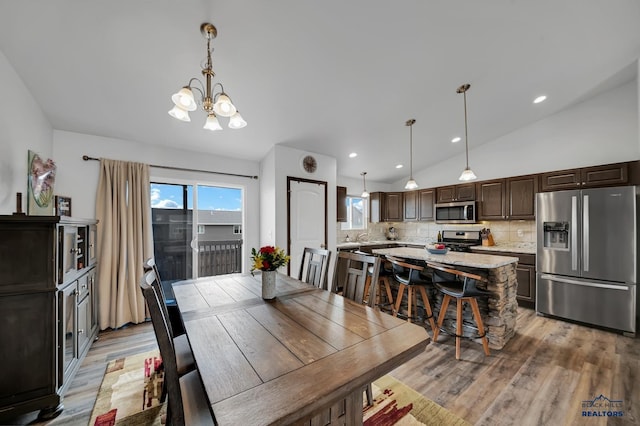 4400 Beringer Dr, Rapid City, SD 57703 - dining room featuring recessed lighting, vaulted ceiling, a chandelier, and light wood-style floors