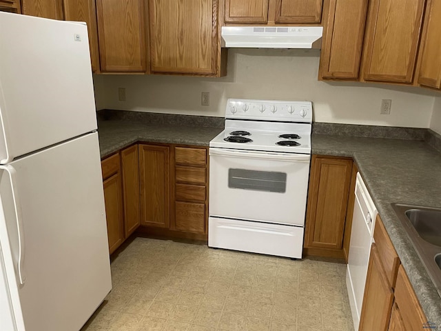 1111 Silver St, Rapid City, SD 57701 - kitchen with white appliances, under cabinet range hood, dark countertops, brown cabinetry, and light floors