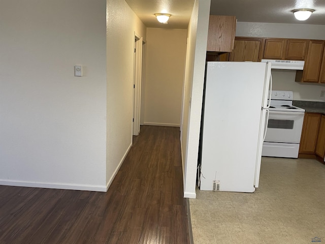 1111 Silver St, Rapid City, SD 57701 - kitchen featuring tile patterned floors, range hood, brown cabinets, baseboards, and white appliances