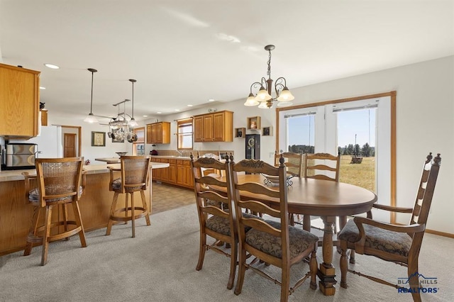 dining room with light carpet, a healthy amount of sunlight, a chandelier, and recessed lighting