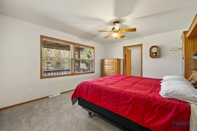 carpeted bedroom featuring a ceiling fan, baseboards, and visible vents