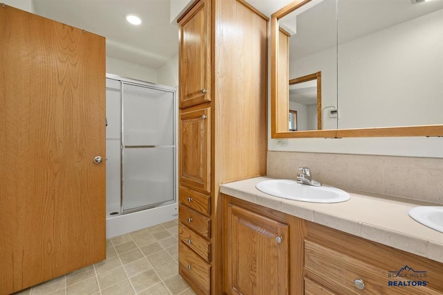 full bath with tile patterned flooring, vanity, a stall shower, and recessed lighting
