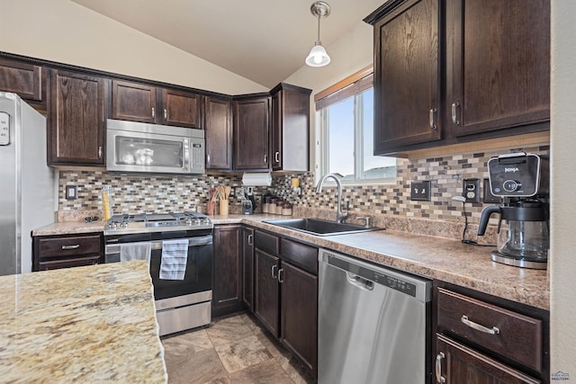 kitchen with stainless steel appliances, dark brown cabinets, lofted ceiling, a sink, and backsplash