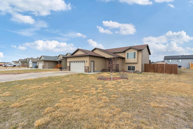view of front of house featuring concrete driveway, fence, a front lawn, a residential view, and a garage