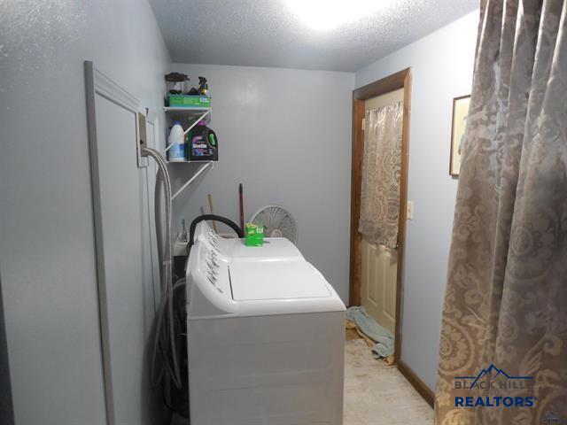 23508 Main St, Caputa, SD 57725 - laundry area with independent washer and dryer, a textured ceiling, and light carpet