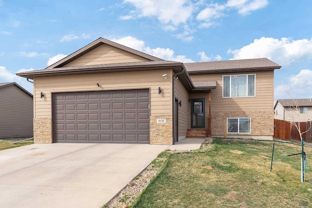 view of front of property with a front yard, driveway, a garage, and fence