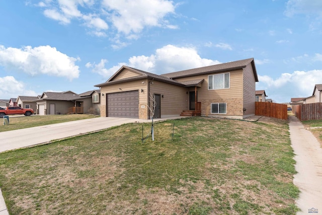 view of front of property featuring a front yard, driveway, a garage, and fence