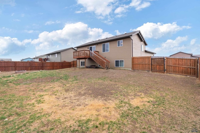 rear view of house with a gate, a fenced backyard, a wooden deck, and stairway