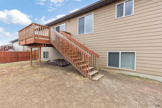 back of house featuring stairs, a deck, and fence