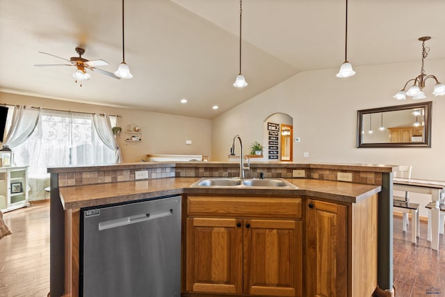kitchen featuring stainless steel dishwasher, a sink, arched walkways, ceiling fan, and wood finished floors
