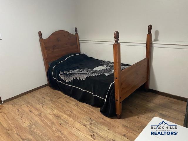 bedroom with baseboards and wood finished floors