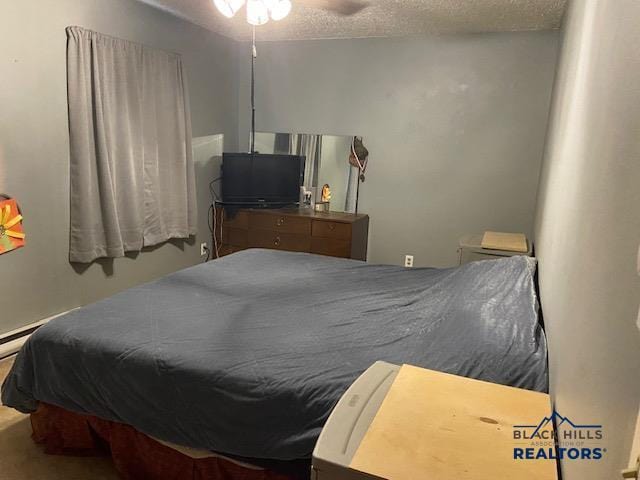 bedroom with a ceiling fan and a textured ceiling