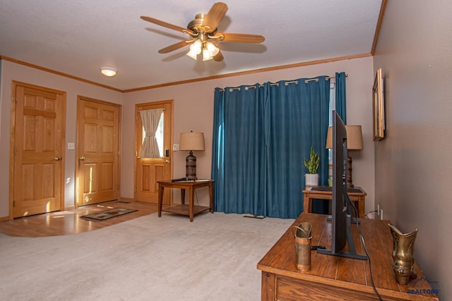 carpeted foyer entrance featuring crown molding and a ceiling fan