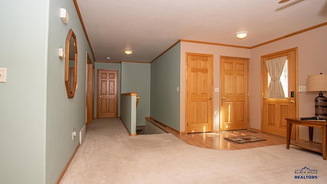 entryway with baseboards, ornamental molding, and carpet flooring