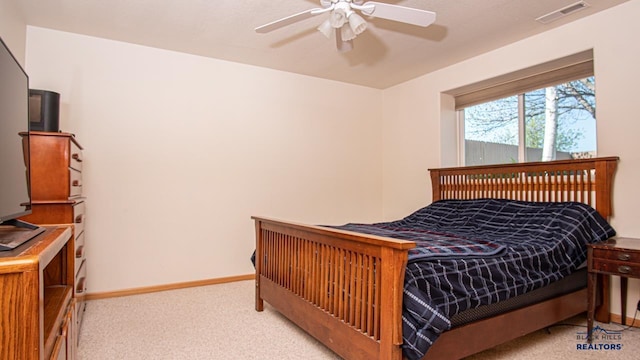 bedroom featuring light carpet, baseboards, and a ceiling fan
