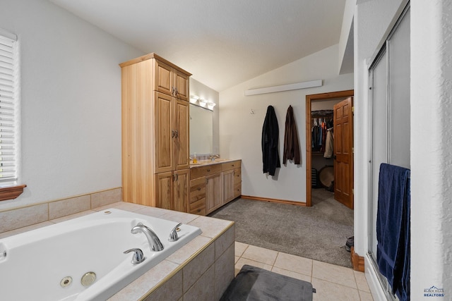 23863 Emerald Pines Dr, Hill City, SD 57745 - bathroom featuring tile patterned flooring, vanity, a walk in closet, lofted ceiling, and a tub with jets