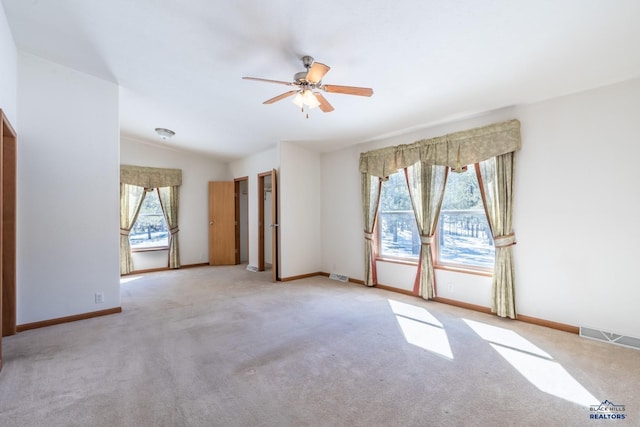 carpeted empty room with a ceiling fan, baseboards, a healthy amount of sunlight, and lofted ceiling