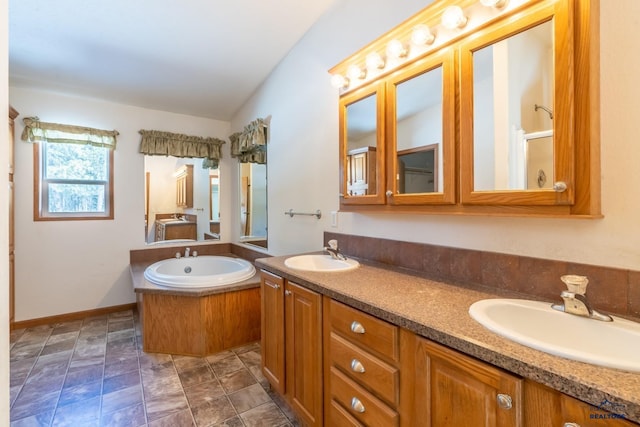 bathroom featuring double vanity, a bath, and a sink