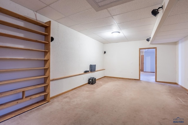 interior space featuring baseboards, carpet floors, and a drop ceiling