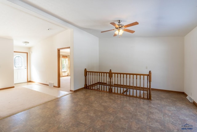 unfurnished room featuring baseboards, visible vents, and a ceiling fan