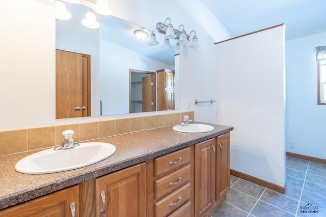 full bathroom featuring double vanity, tasteful backsplash, tile patterned flooring, and a sink