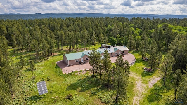 drone / aerial view featuring a wooded view