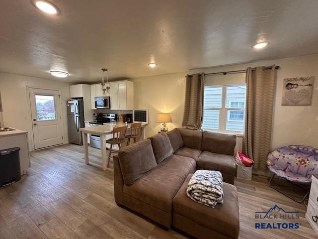 living room with light wood-style flooring and recessed lighting