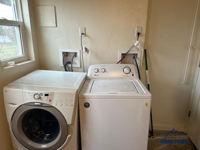 clothes washing area featuring independent washer and dryer, laundry area, and baseboards