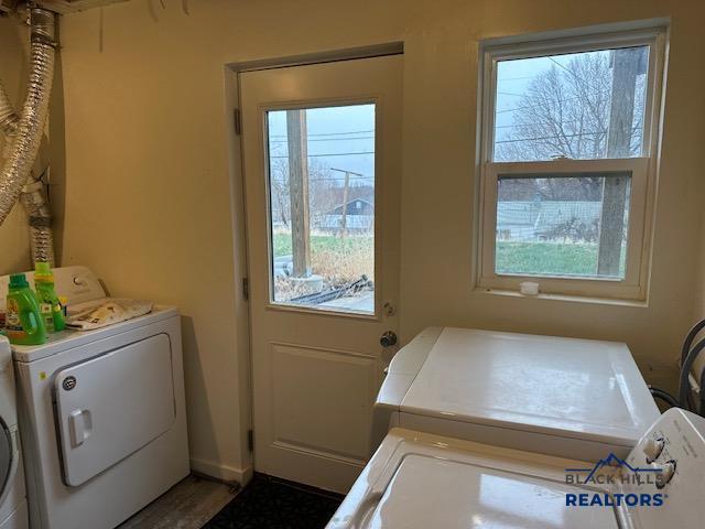 clothes washing area featuring washer and clothes dryer and laundry area