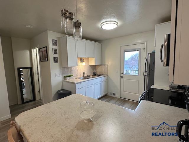 kitchen featuring white cabinets, light countertops, a sink, and appliances with stainless steel finishes