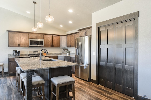 21260 Ridgewood Trl, Lead, SD 57754 - kitchen featuring light stone counters, a sink, appliances with stainless steel finishes, dark wood finished floors, and lofted ceiling