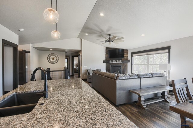 21260 Ridgewood Trl, Lead, SD 57754 - living area featuring vaulted ceiling, a ceiling fan, a fireplace, a textured ceiling, and dark wood-type flooring