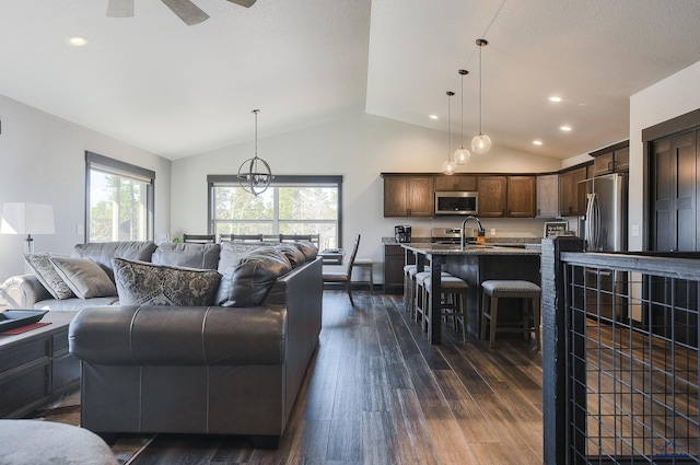 21260 Ridgewood Trl, Lead, SD 57754 - living area featuring dark wood-style floors, vaulted ceiling, a ceiling fan, and a wealth of natural light
