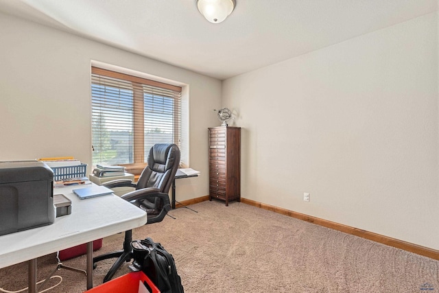 office area featuring light carpet and baseboards