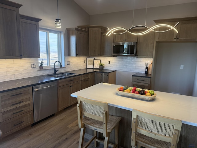 1230 Pinnacle Ct, Rapid City, SD 57701 - kitchen with stainless steel appliances, a sink, dark wood-style flooring, and tasteful backsplash