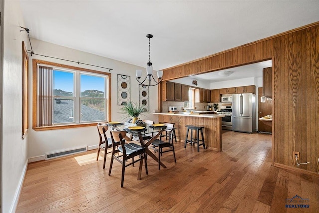 37 Washington St, Deadwood, SD 57732 - dining area with visible vents, light wood-style floors, wood walls, and a chandelier