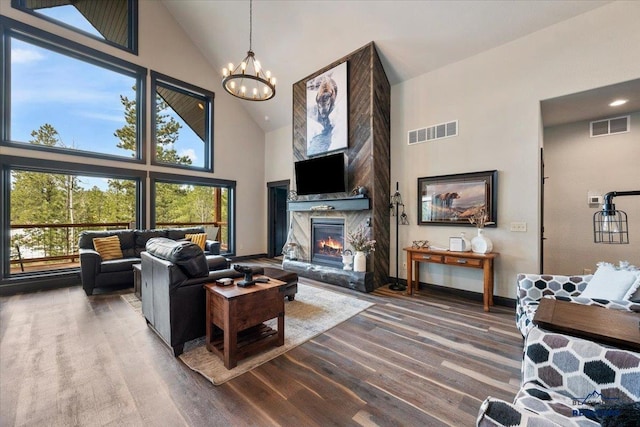 living area featuring visible vents, high vaulted ceiling, a fireplace, and a chandelier