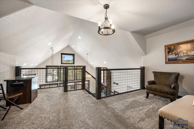 living area featuring an upstairs landing, carpet flooring, and a textured ceiling