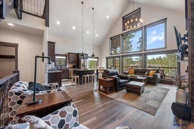 living area featuring high vaulted ceiling, wood finished floors, a chandelier, and recessed lighting