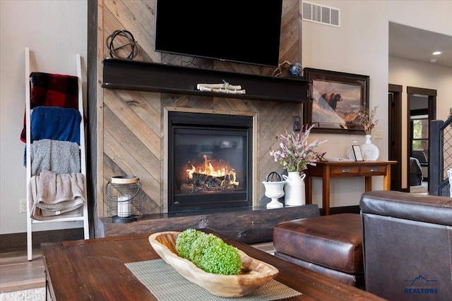 living room with a glass covered fireplace and visible vents