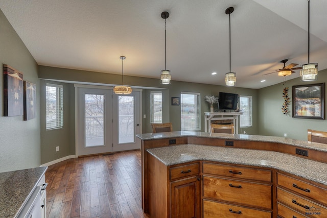 4153 Augusta Dr, Rapid City, SD 57703 - kitchen with hardwood / wood-style flooring, ceiling fan, light stone countertops, brown cabinetry, and a fireplace