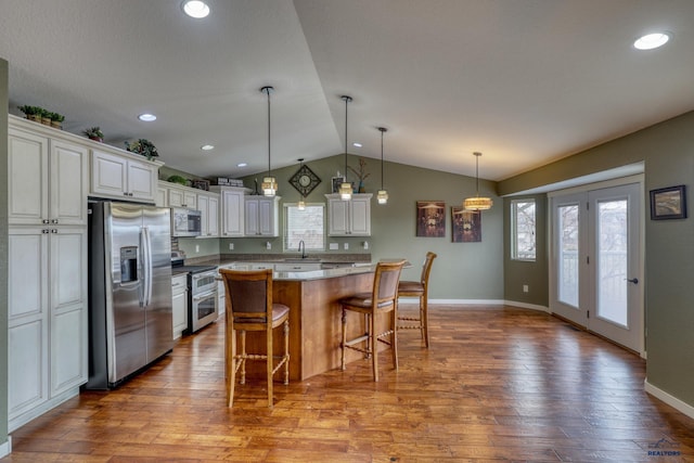 4153 Augusta Dr, Rapid City, SD 57703 - kitchen featuring vaulted ceiling, a sink, a kitchen bar, a center island, and stainless steel appliances