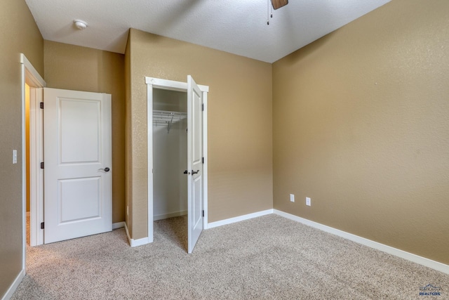 4153 Augusta Dr, Rapid City, SD 57703 - unfurnished bedroom with a closet, baseboards, light colored carpet, ceiling fan, and a textured wall