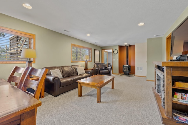 24354 Rushmore Ranch Rd, Keystone, SD 57751 - carpeted living room with recessed lighting, baseboards, a wood stove, and visible vents