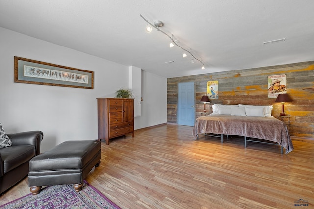 24354 Rushmore Ranch Rd, Keystone, SD 57751 - bedroom featuring baseboards, wooden walls, and light wood-style flooring
