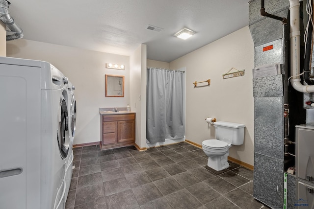 24354 Rushmore Ranch Rd, Keystone, SD 57751 - full bath featuring vanity, washer and clothes dryer, toilet, visible vents, and curtained shower