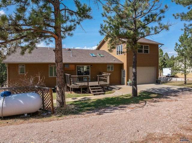 24354 Rushmore Ranch Rd, Keystone, SD 57751 - rear view of property featuring driveway, an attached garage, and a deck